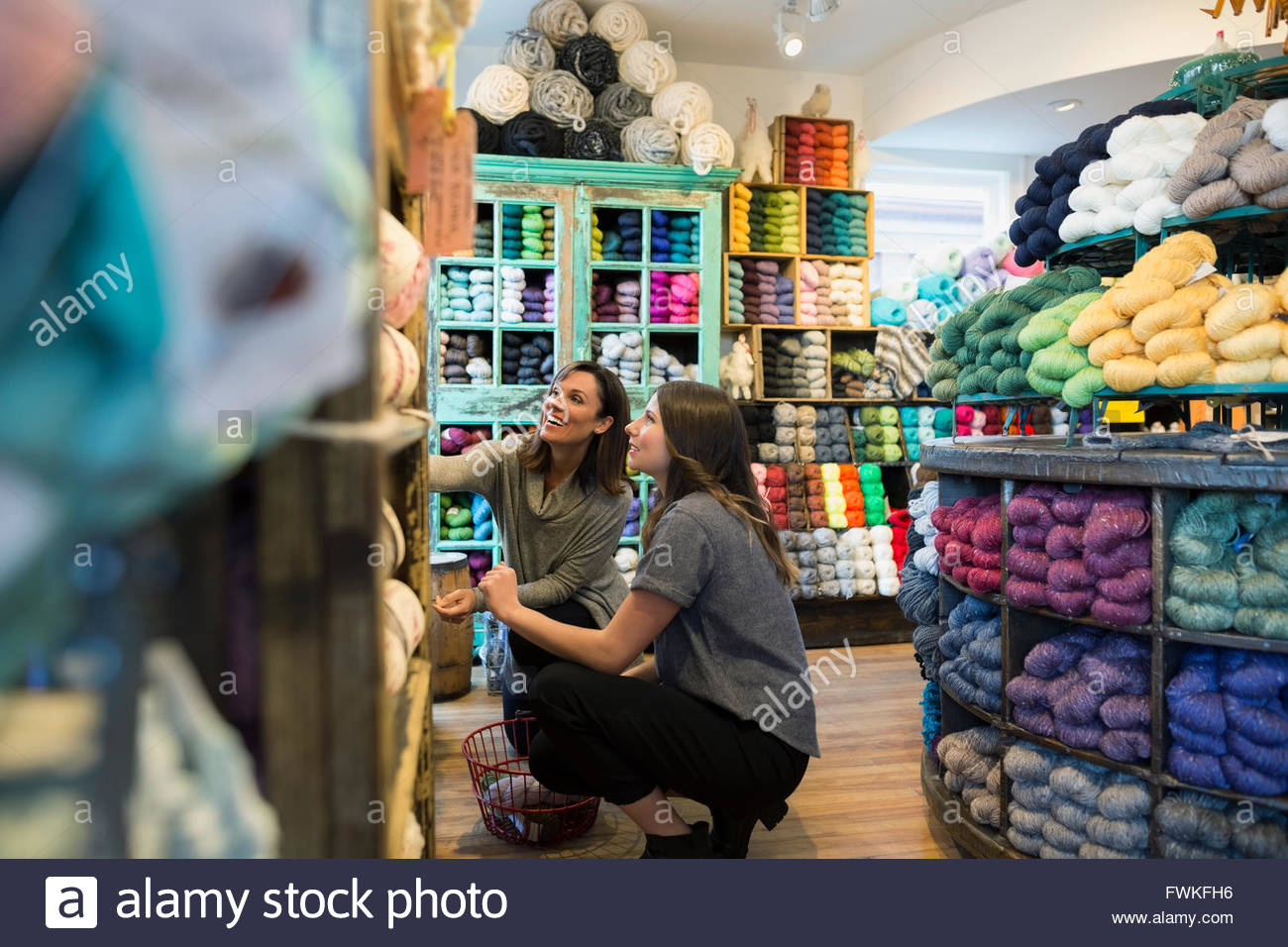Yarn store owner helping customer Stock Photo Alamy