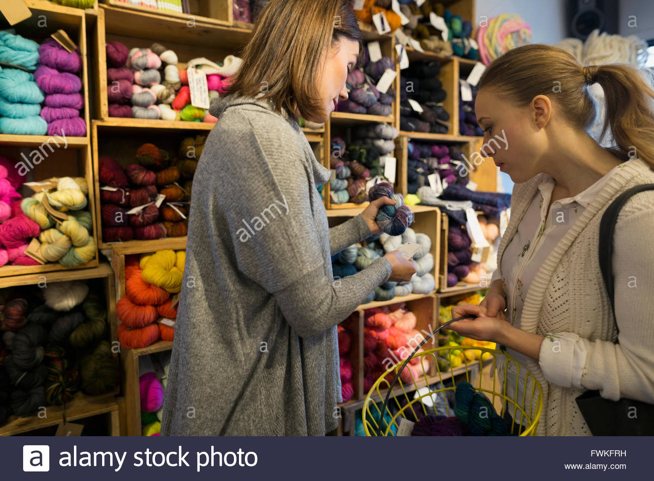 Yarn store owner helping customer Stock Photo Alamy