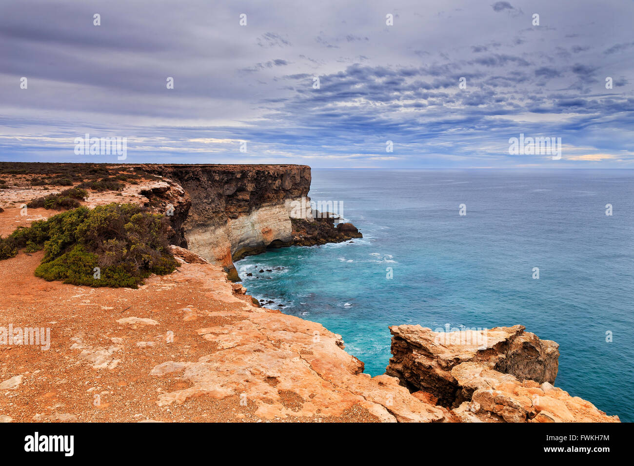 Bend of rocky dangerous geological limestone Nullarbor plato towards Great Australian bight in South Australia on a cloudy say. Stock Photo