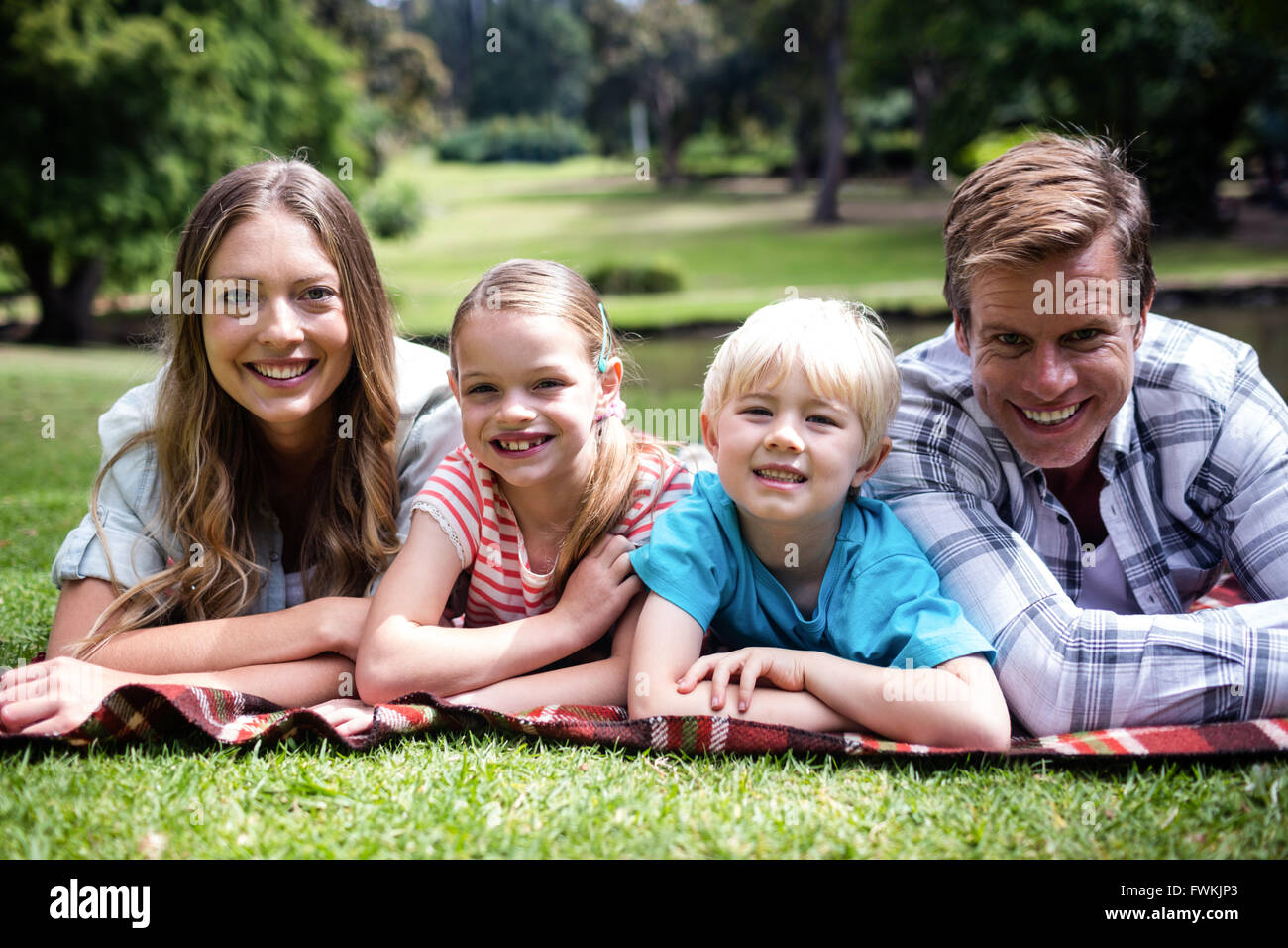 Happy family lying in the park Stock Photo - Alamy
