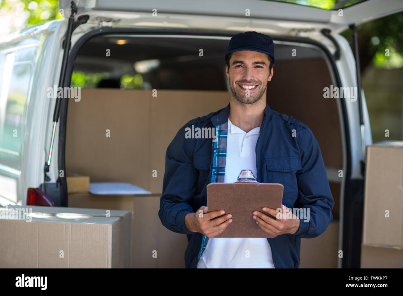 Delivery Man Using Remote Portrait of smart delivery man holding clipboard Stock Photo - Alamy