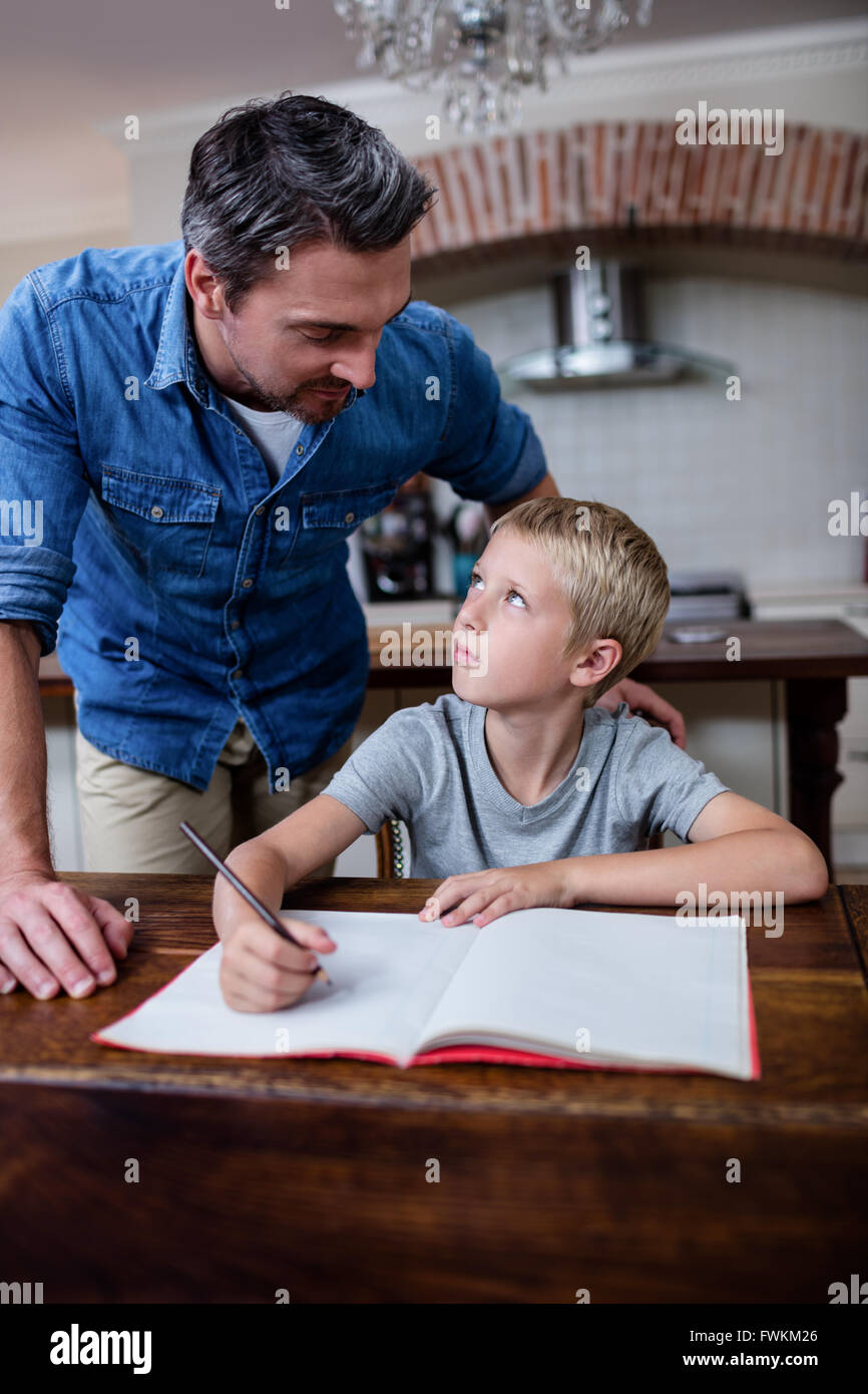 Father helping son with his homework in kitchen Stock Photo - Alamy