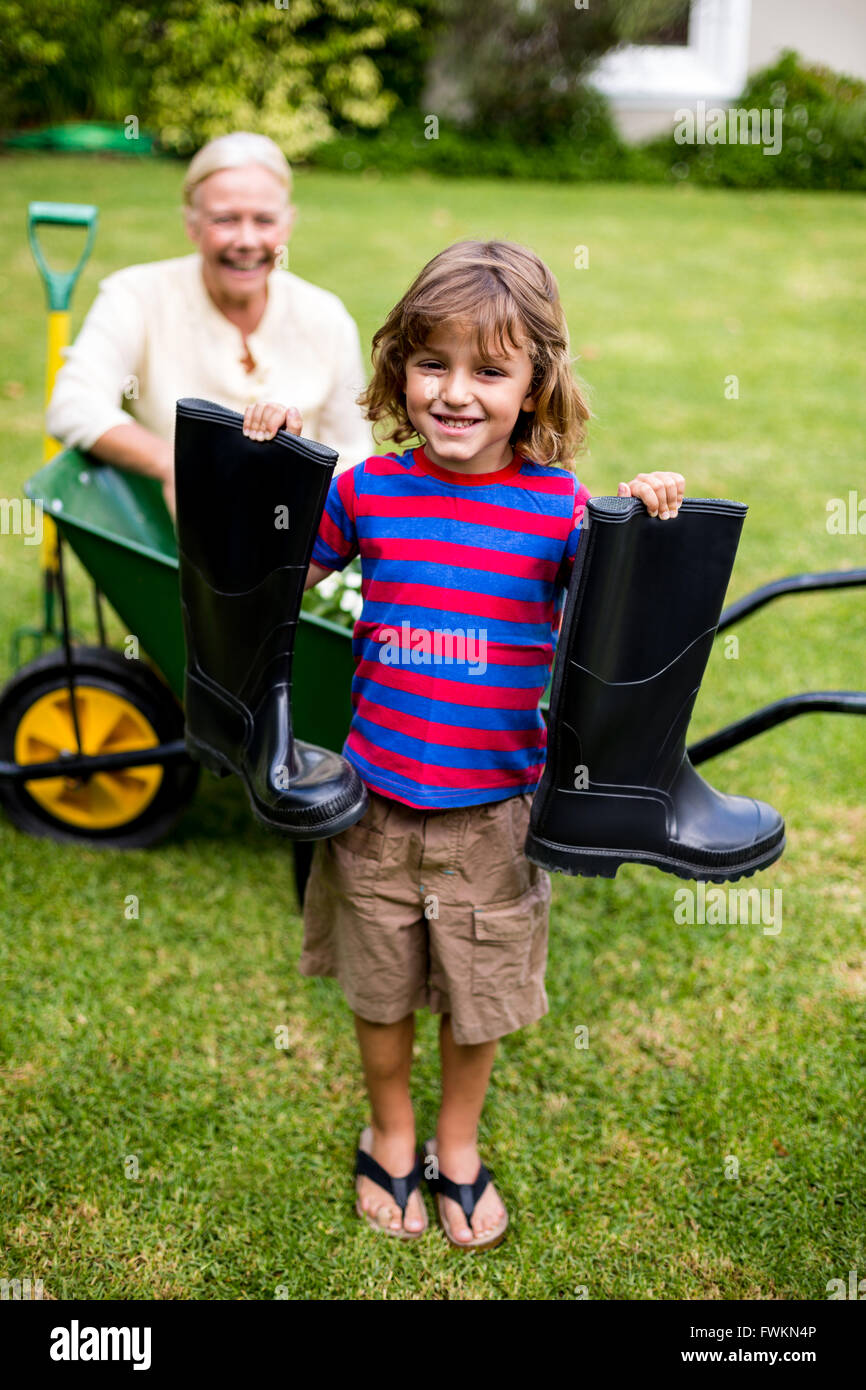 Boy with wellington boots while standing in yard Stock Photo