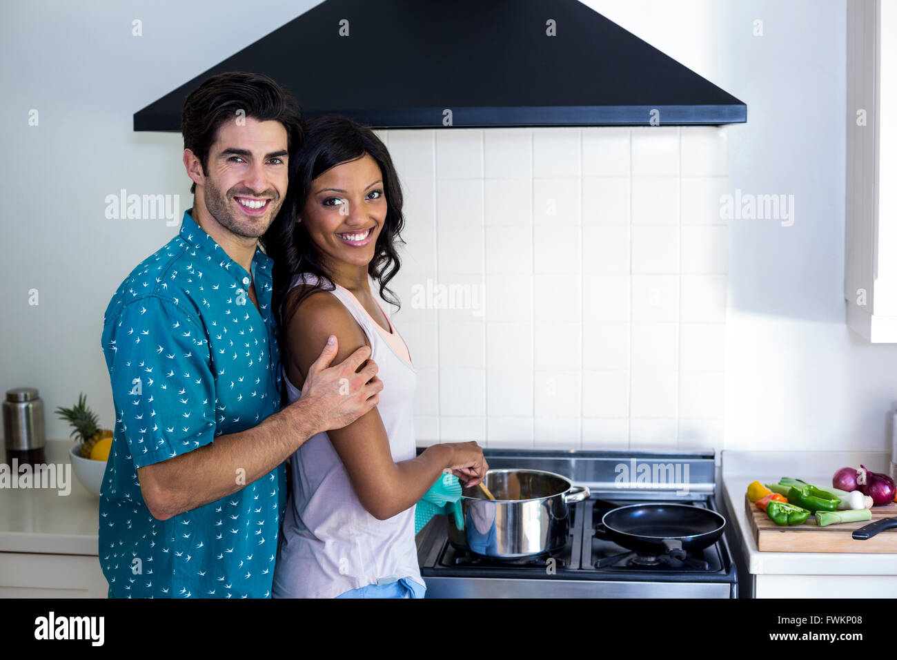 Man embracing woman while cooking in kitchen Stock Photo - Alamy