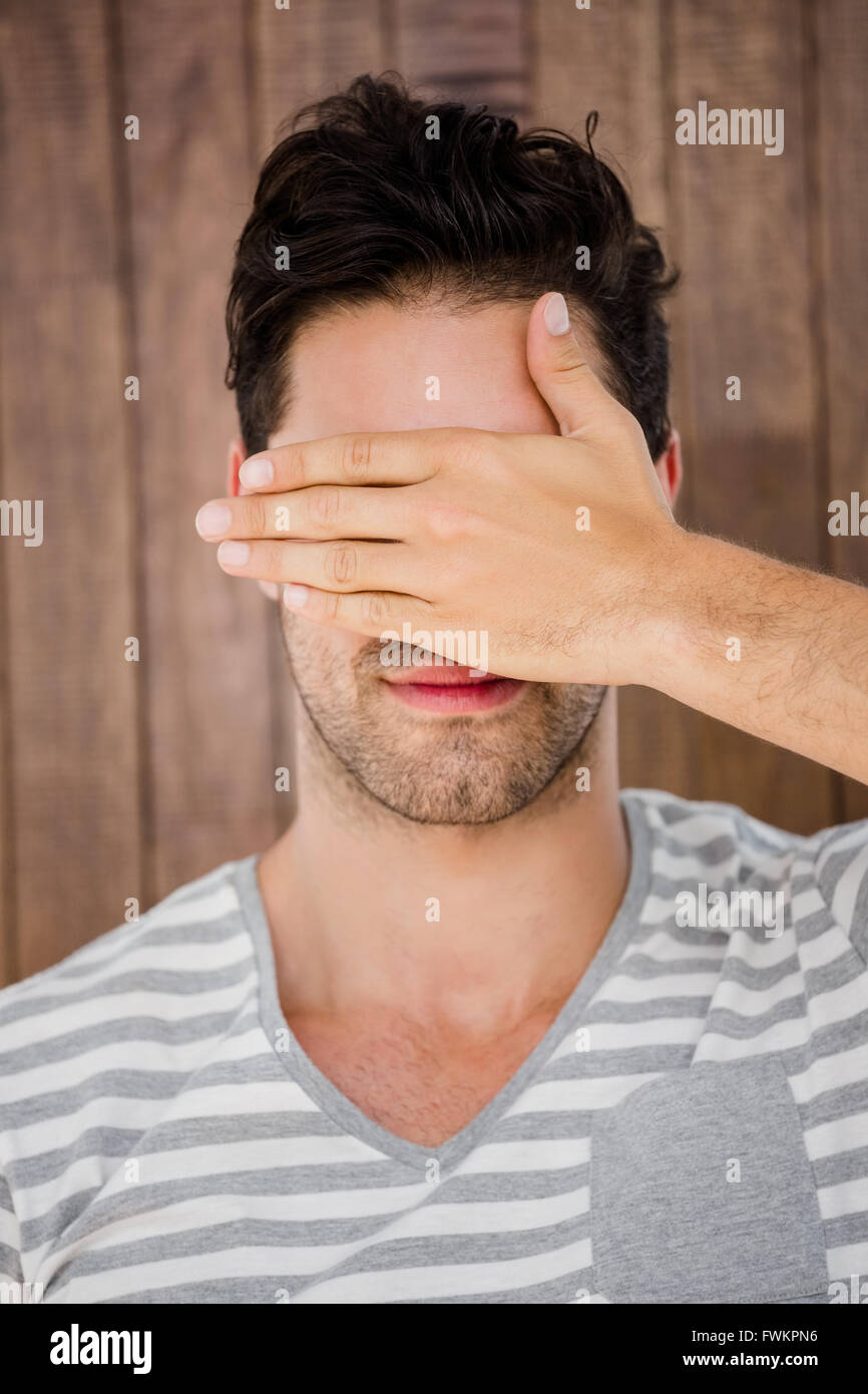 Handsome man covering his eyes Stock Photo - Alamy