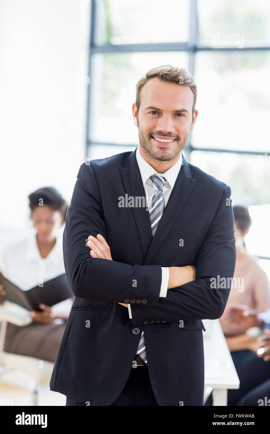 Happy businessman standing with arms crossed Stock Photo - Alamy