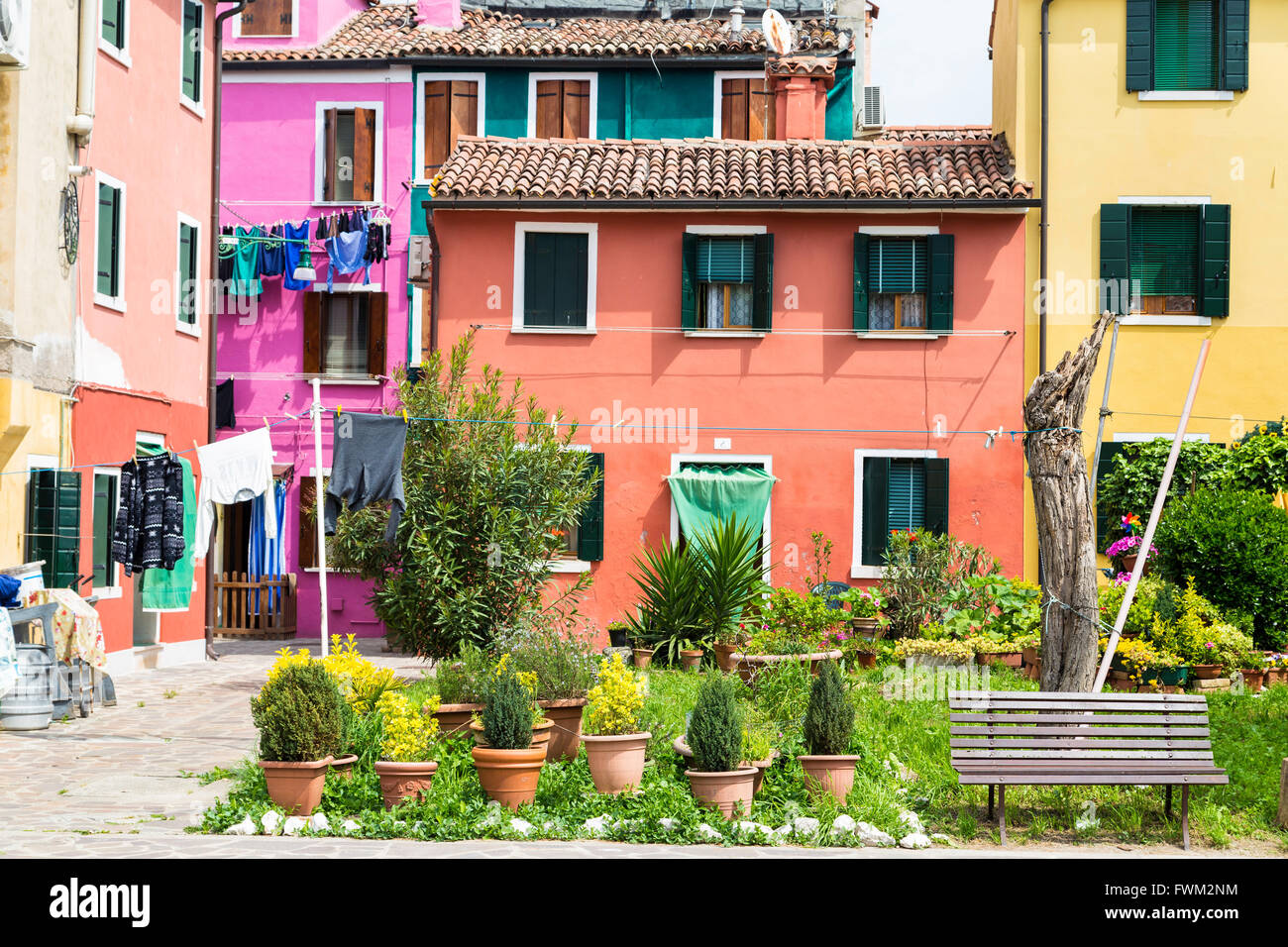 Laundries drying in the middle of the courtyard between traditional colorful houses in Burano island, Venice Stock Photo