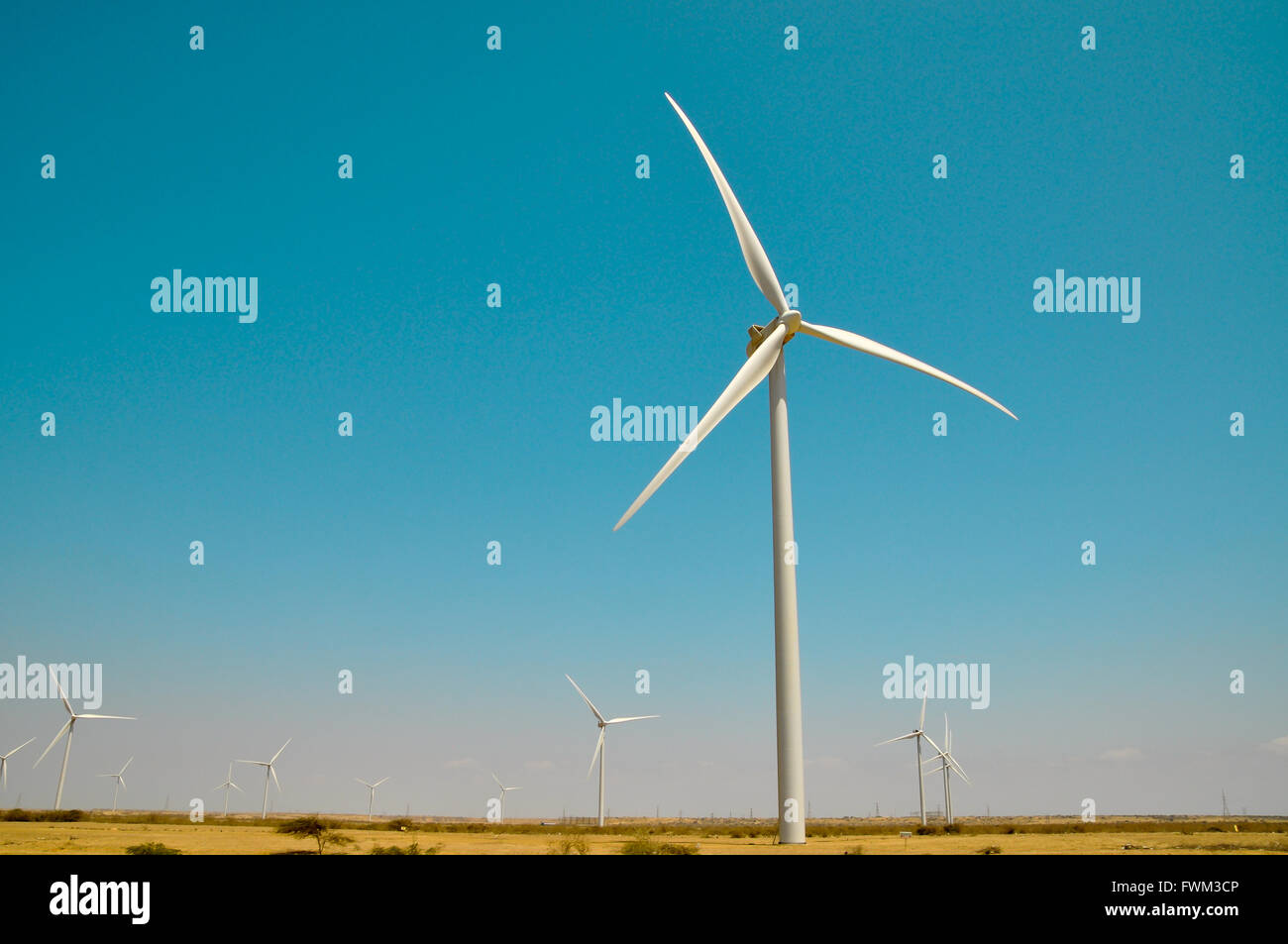 Low Angle View Of Windmills Against Blue Sky Stock Photo