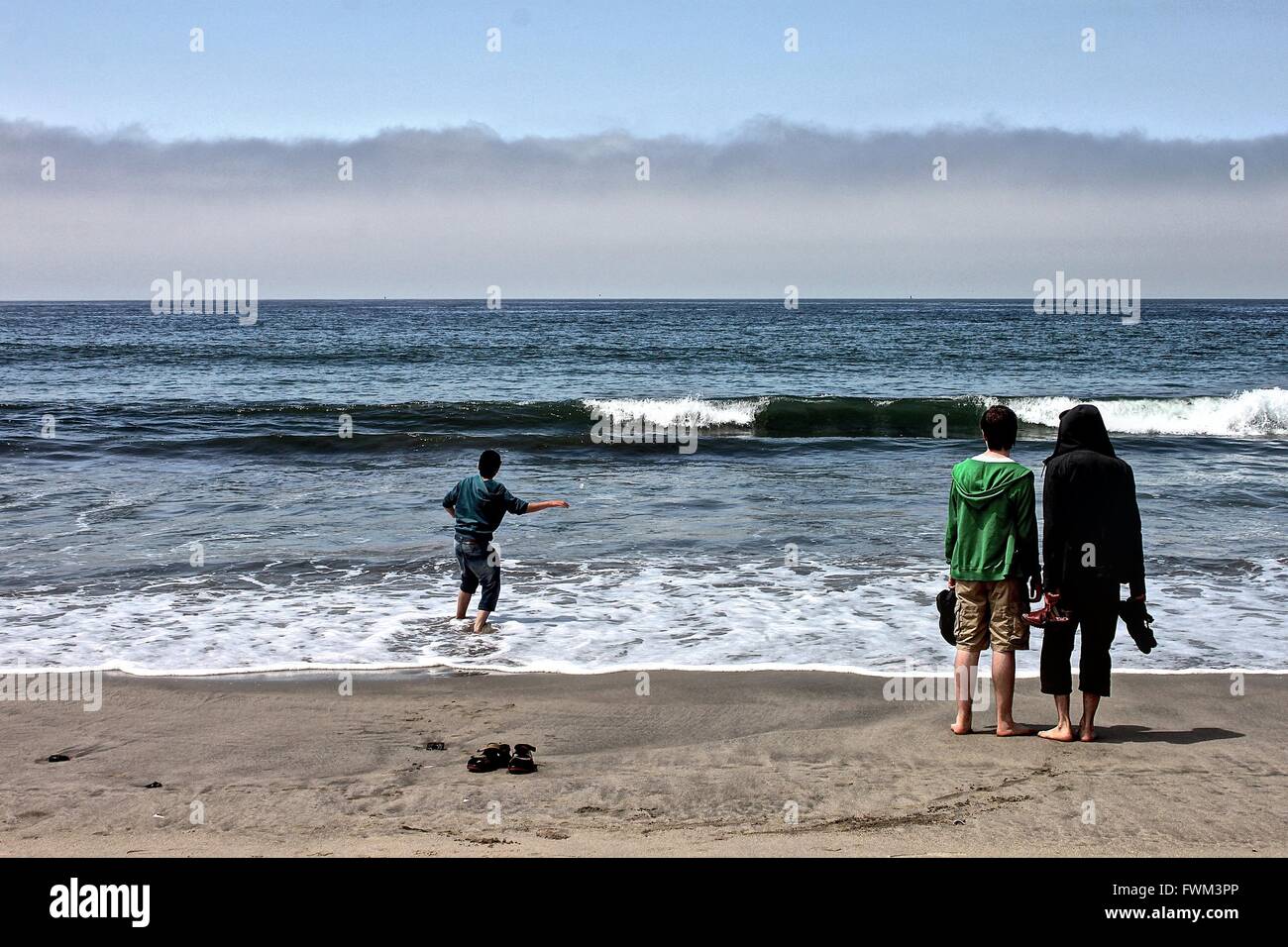 Rear View Of Friends Enjoying At Beach Stock Photo