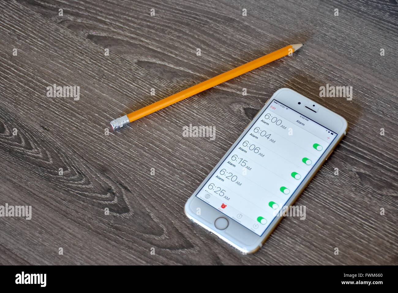 An Apple iPhone 6s displaying the alarm clock application with multiple
