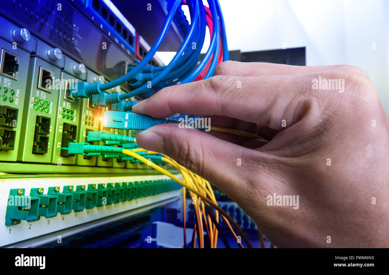Man connecting fiber network cables to switches Stock Photo Alamy