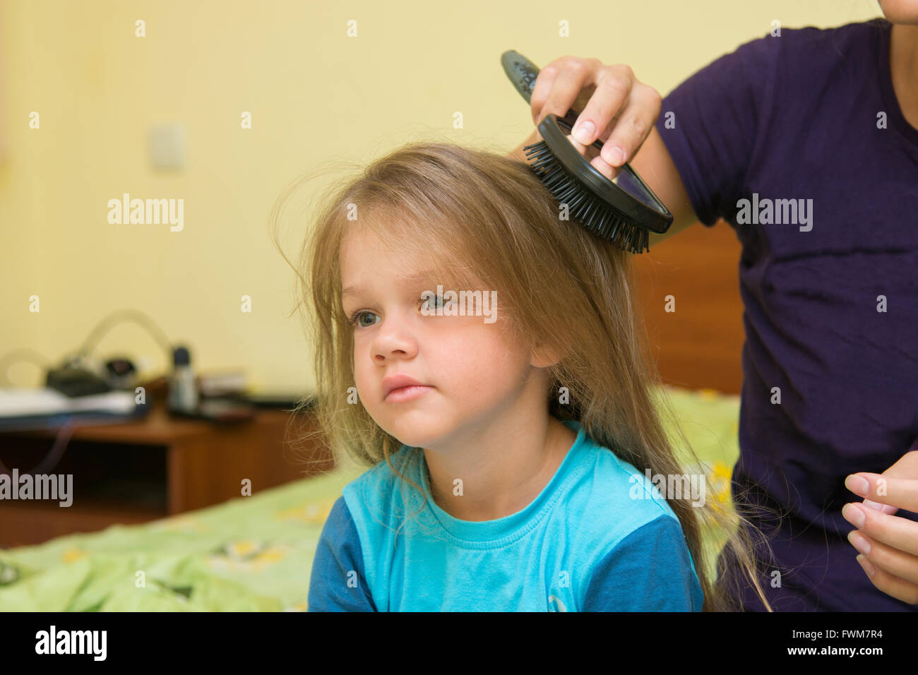Little girl combing her long hair massage comb Stock Photo