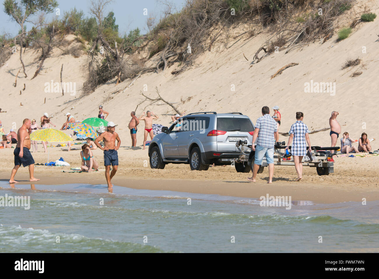 Anapa, Russia - September 20, 2015: Jeep with insolent driver rides on the beach with holidaymakers Stock Photo