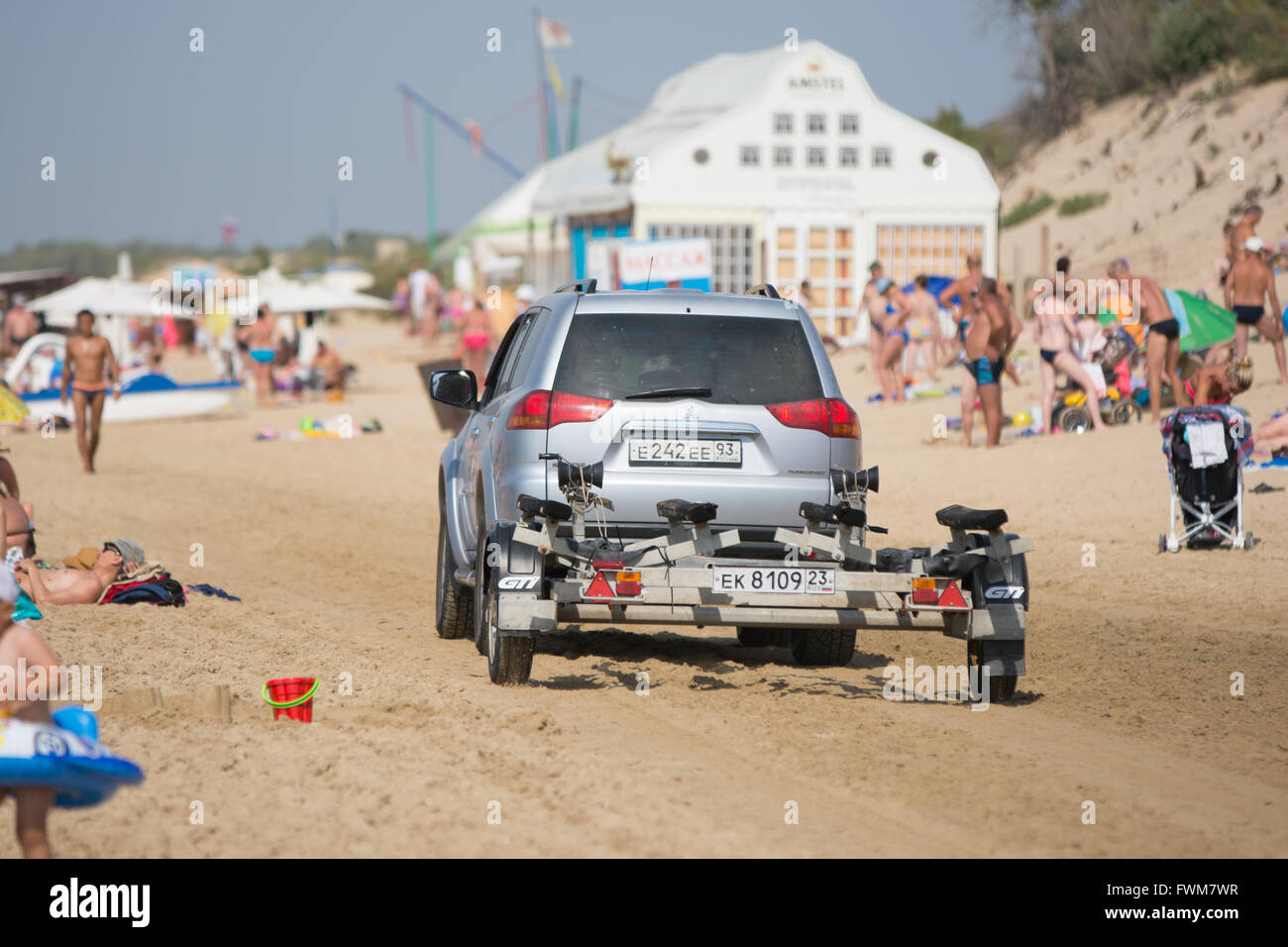 Anapa, Russia - September 20, 2015: passenger car with a trailer, riding on the beach with holidaymakers Stock Photo