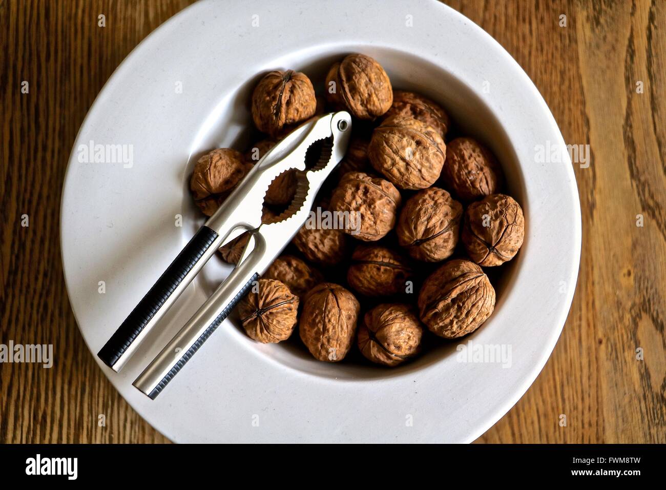 High Angle View Of Walnut And Nut Cracker In Plate Stock Photo