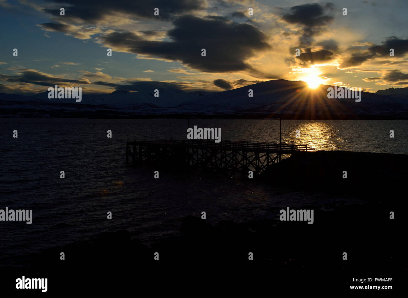 beautiful sunset over snowy mountain, fjord and pier Stock Photo - Alamy