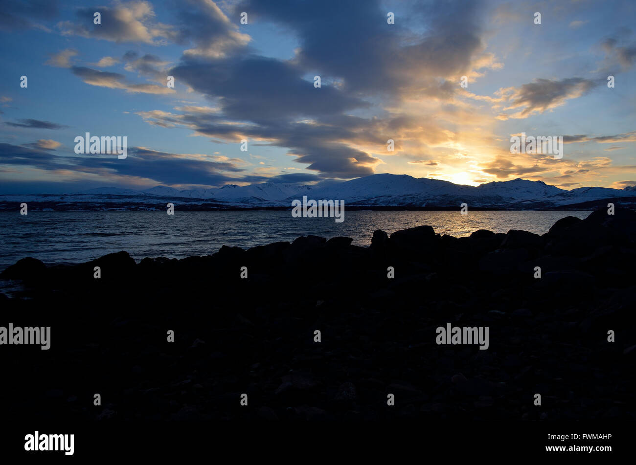 golden vibrant sunset over snowy mountain and fjord landscape Stock ...