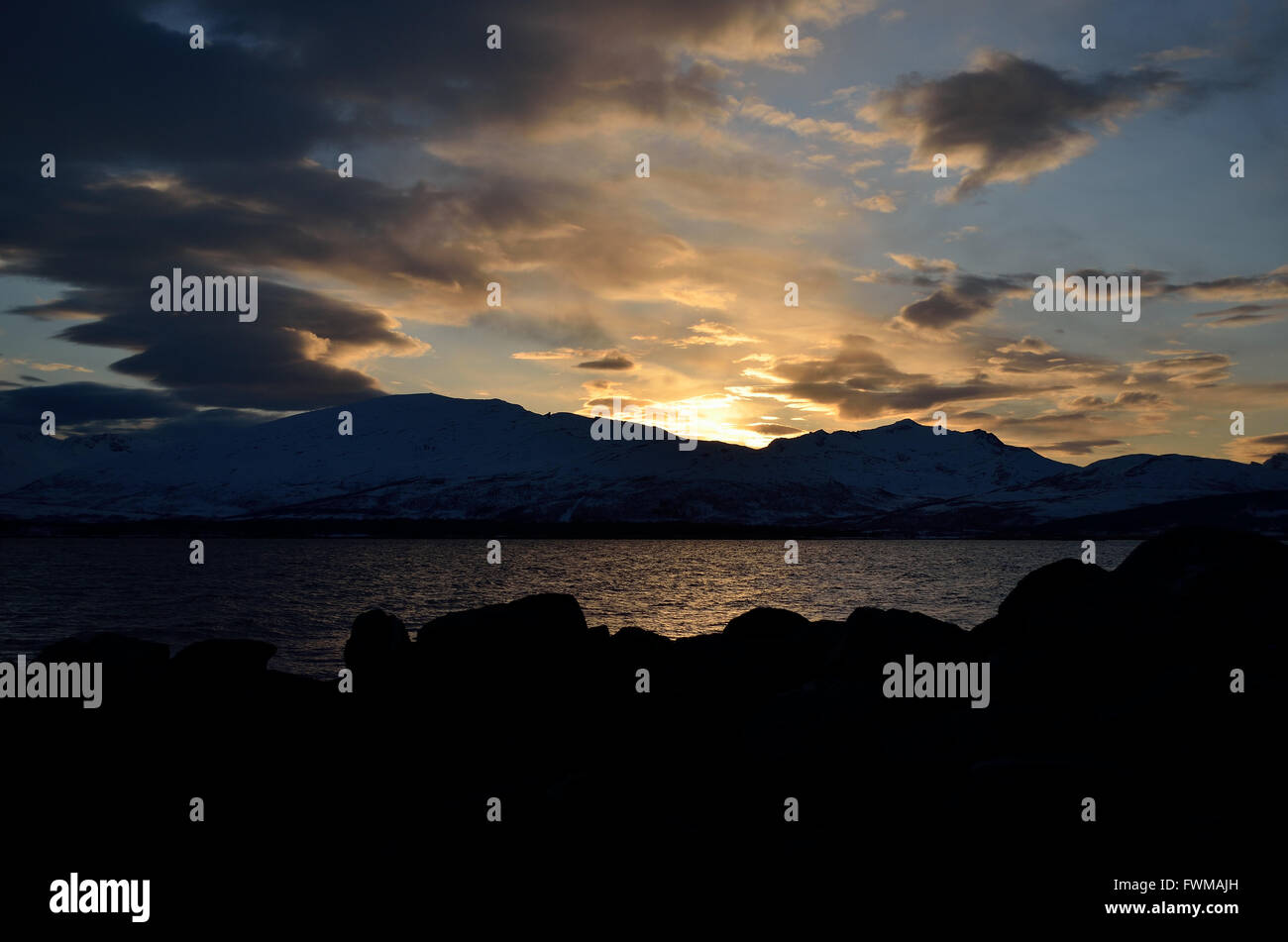 golden vibrant sunset over snowy mountain and fjord landscape Stock ...