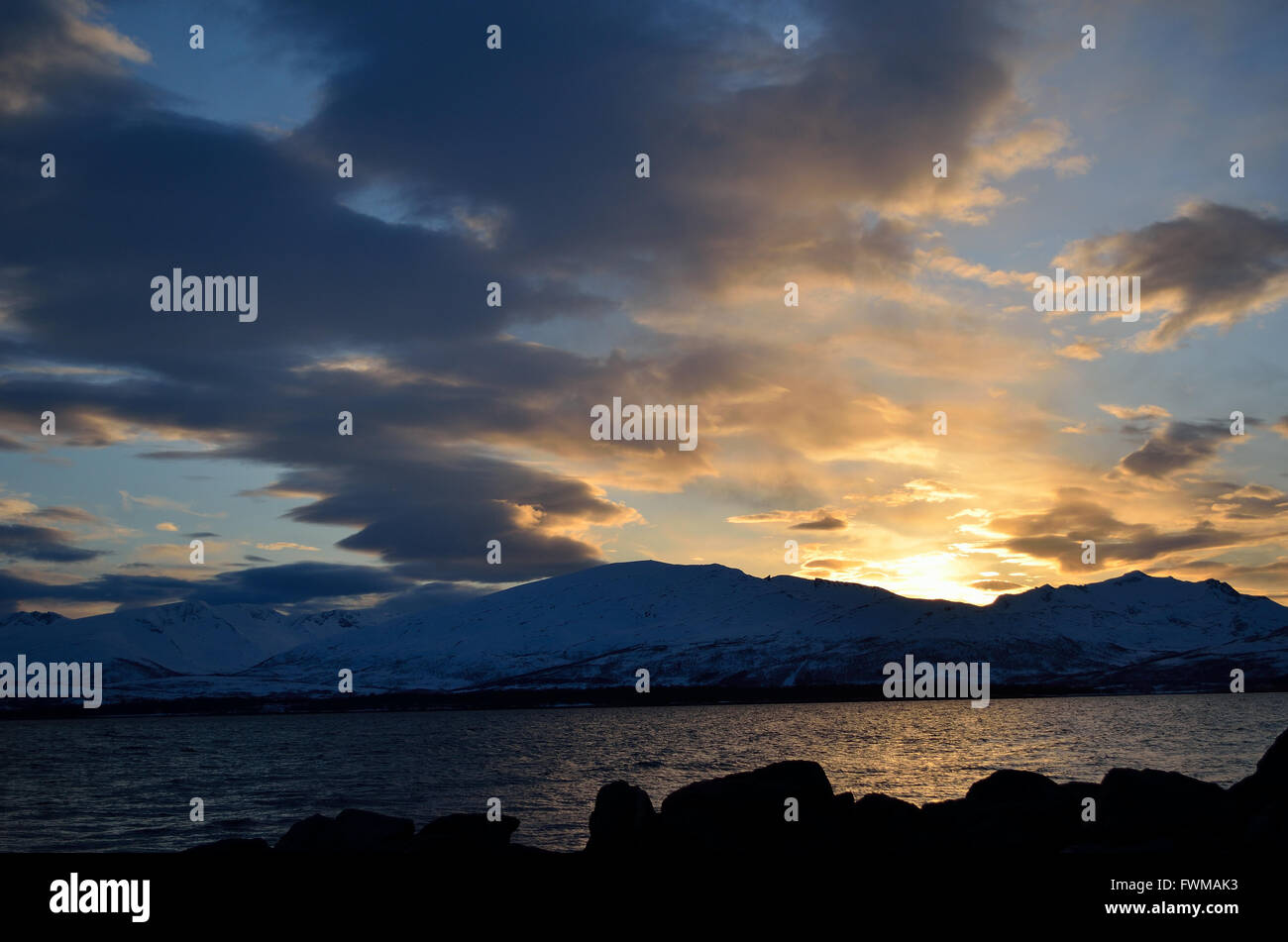 golden vibrant sunset over snowy mountain and fjord landscape Stock ...