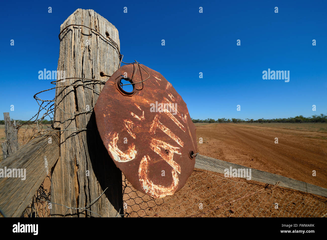 A "Caution Cattle" Sign made from the top of a oil drum wired to a fence in outback Australia Stock Photo