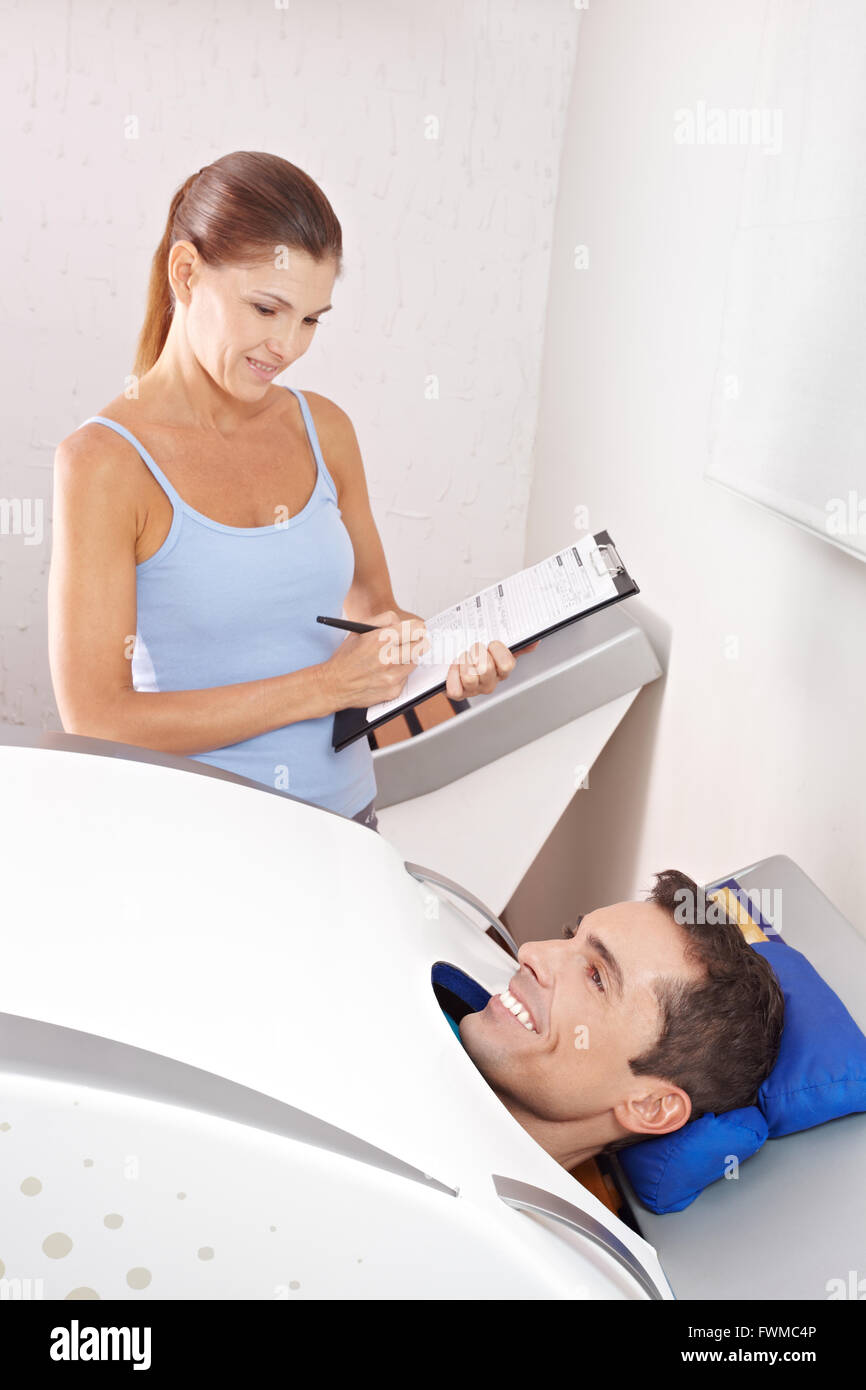Happy man in cabin ozone for skin treatment with fitness trainer in spa Stock Photo