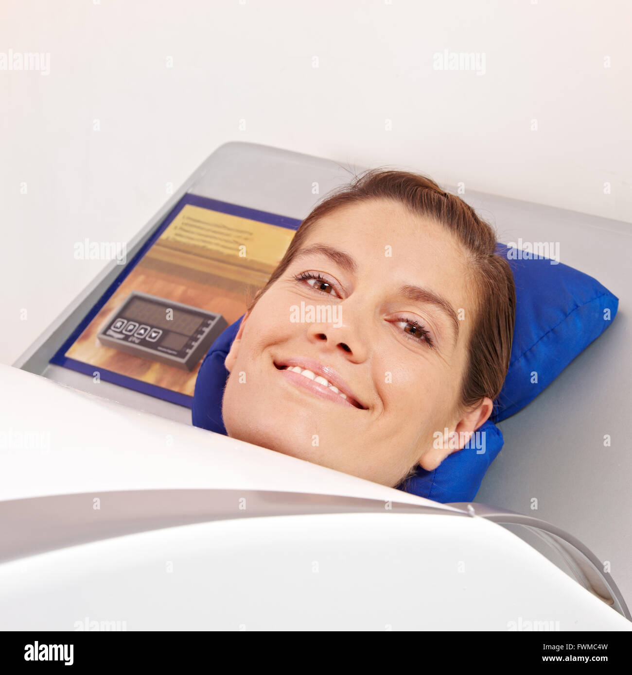 Smiling woman laying in cabin ozone for skin treatment in spa Stock Photo