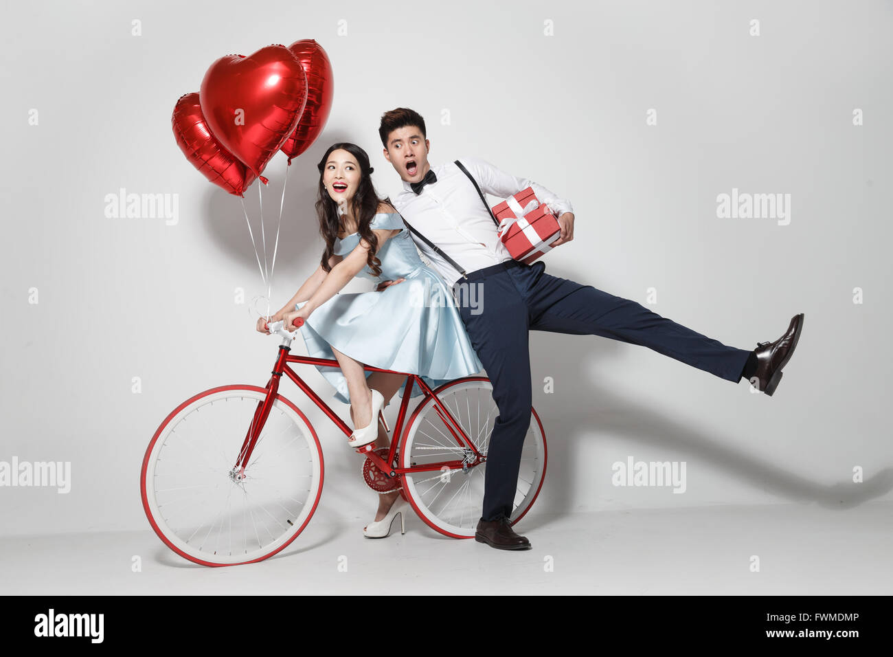 Young couple with heart-shaped balloons and gift Stock Photo - Alamy