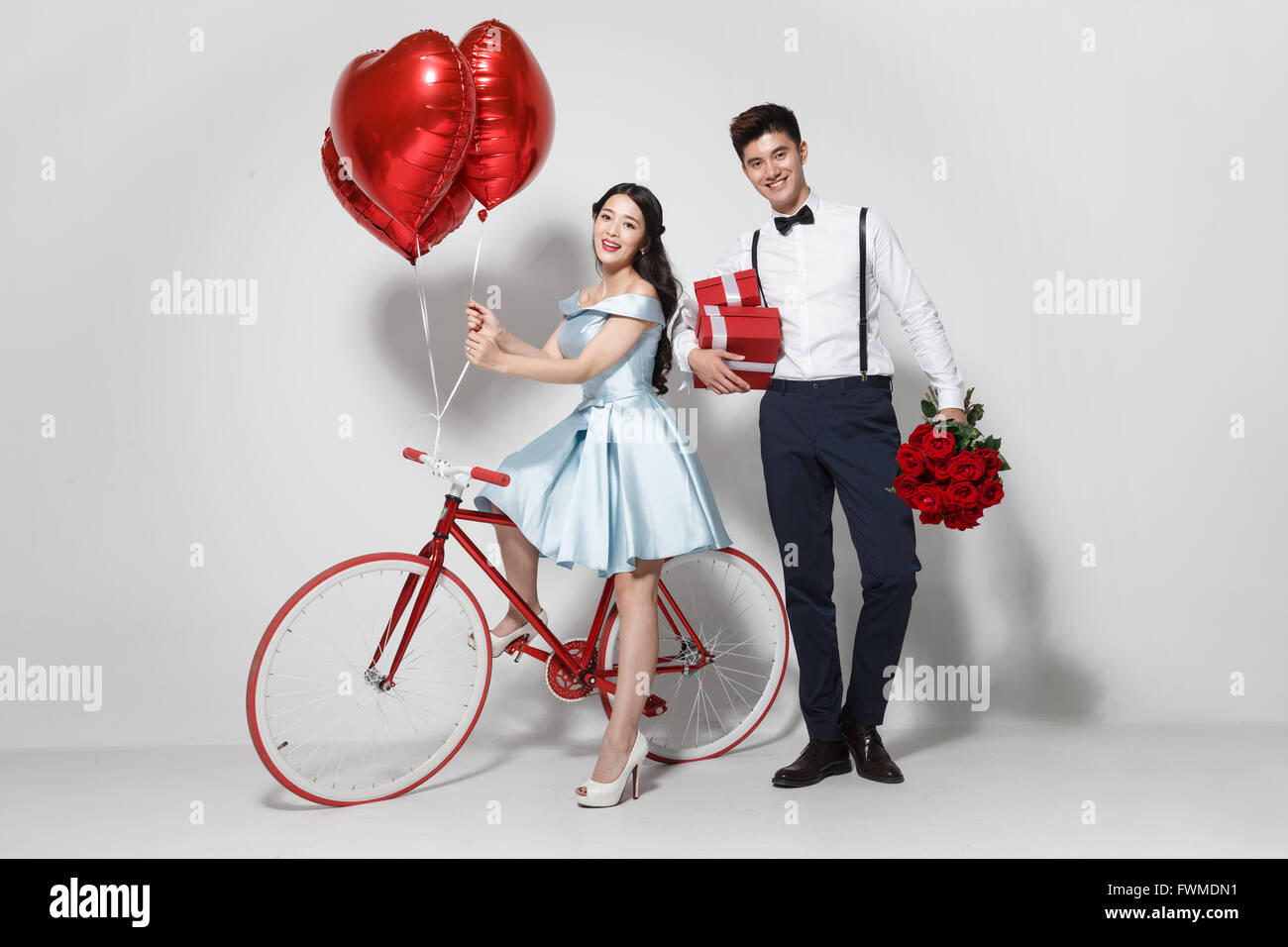 Young couple with heart-shaped balloons and gift Stock Photo - Alamy