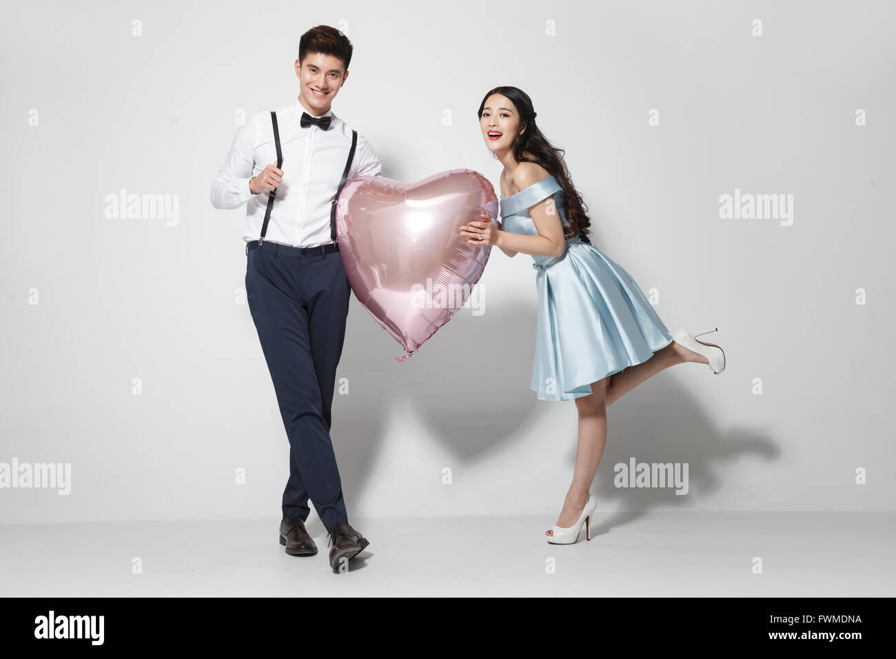 Young couple with heart-shaped balloon Stock Photo - Alamy