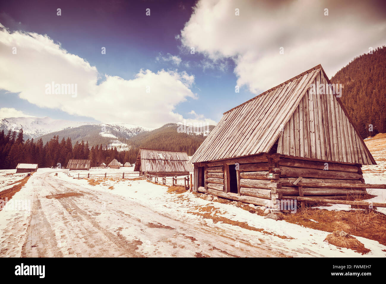 Old film retro stylized wooden hut by a road in Tatra Mountains, end of  winter and beginning of spring, Poland Stock Photo - Alamy