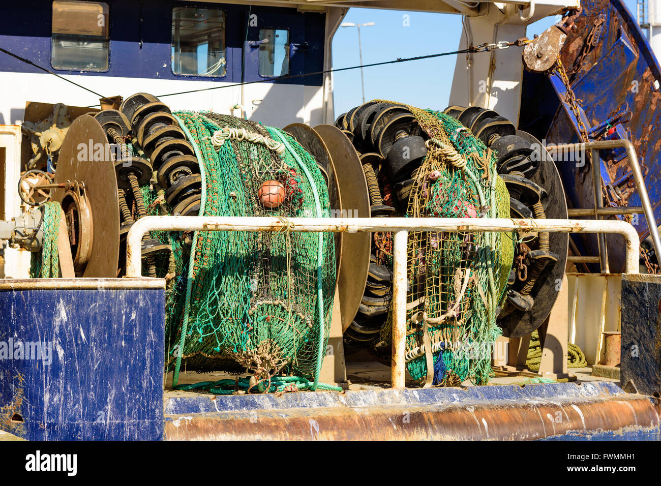 Rolled up fishing nets or trawls on the stern of a trawler fishing boat. Stock Photo
