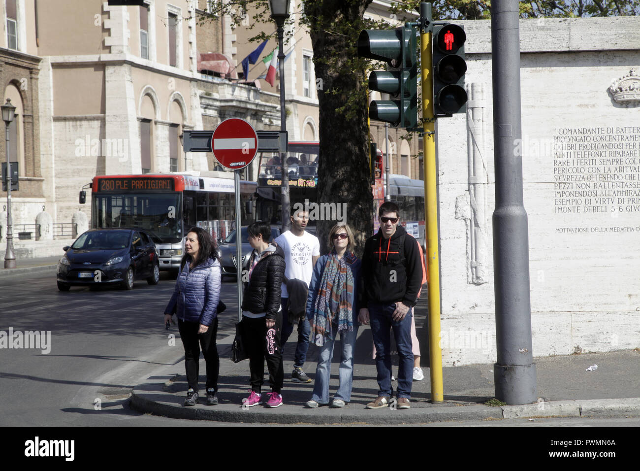 Pedestrians waiting the green light to cross the street in a sunny day at Rome, Italy Stock Photo
