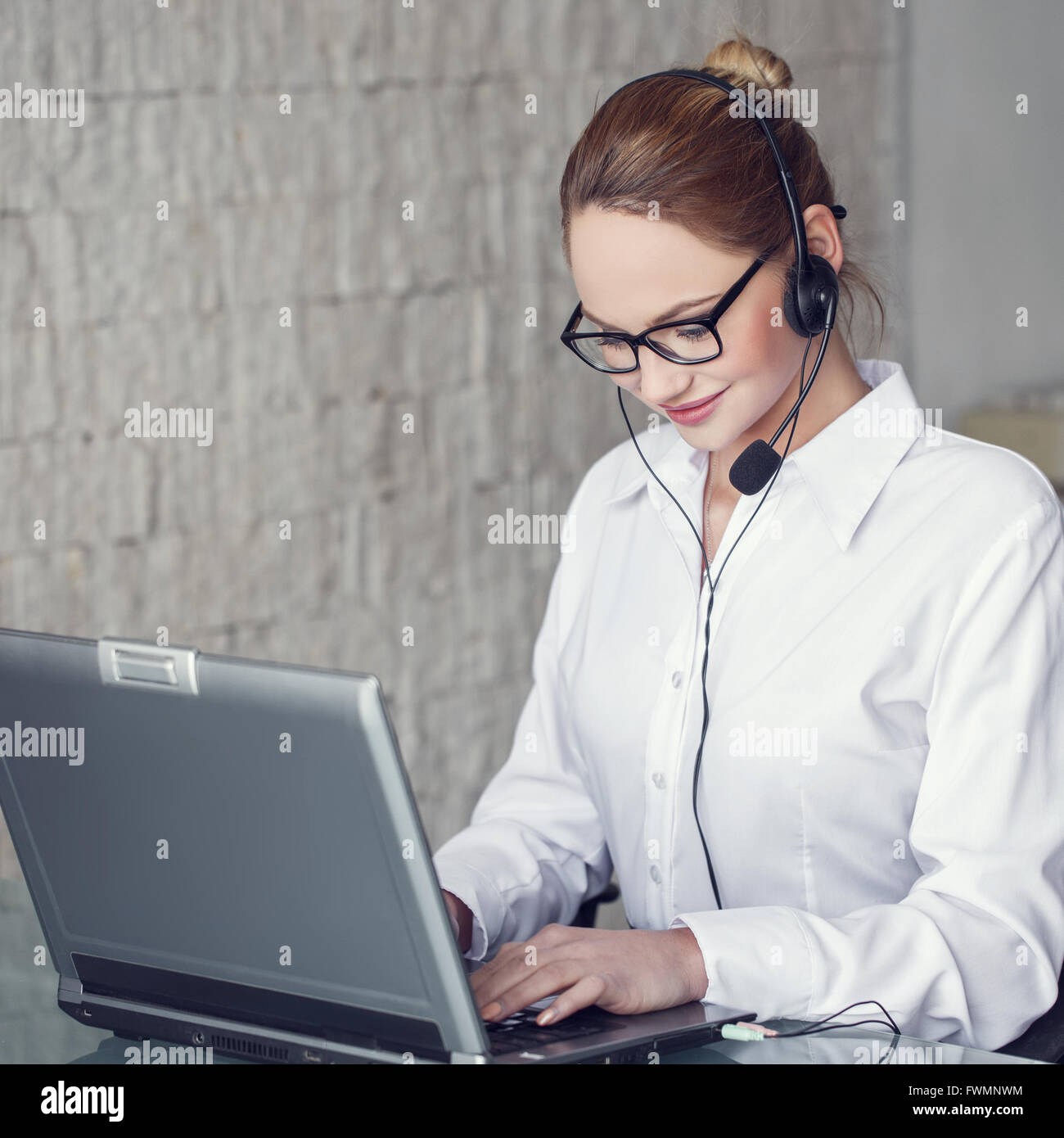 Customer support in office, young woman with headset Stock Photo