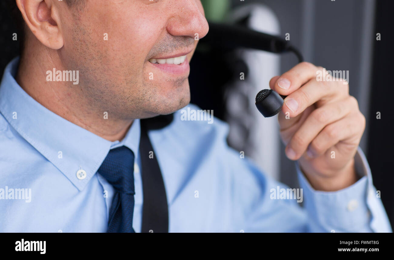 close up of happy bus driver talking to microphone Stock Photo