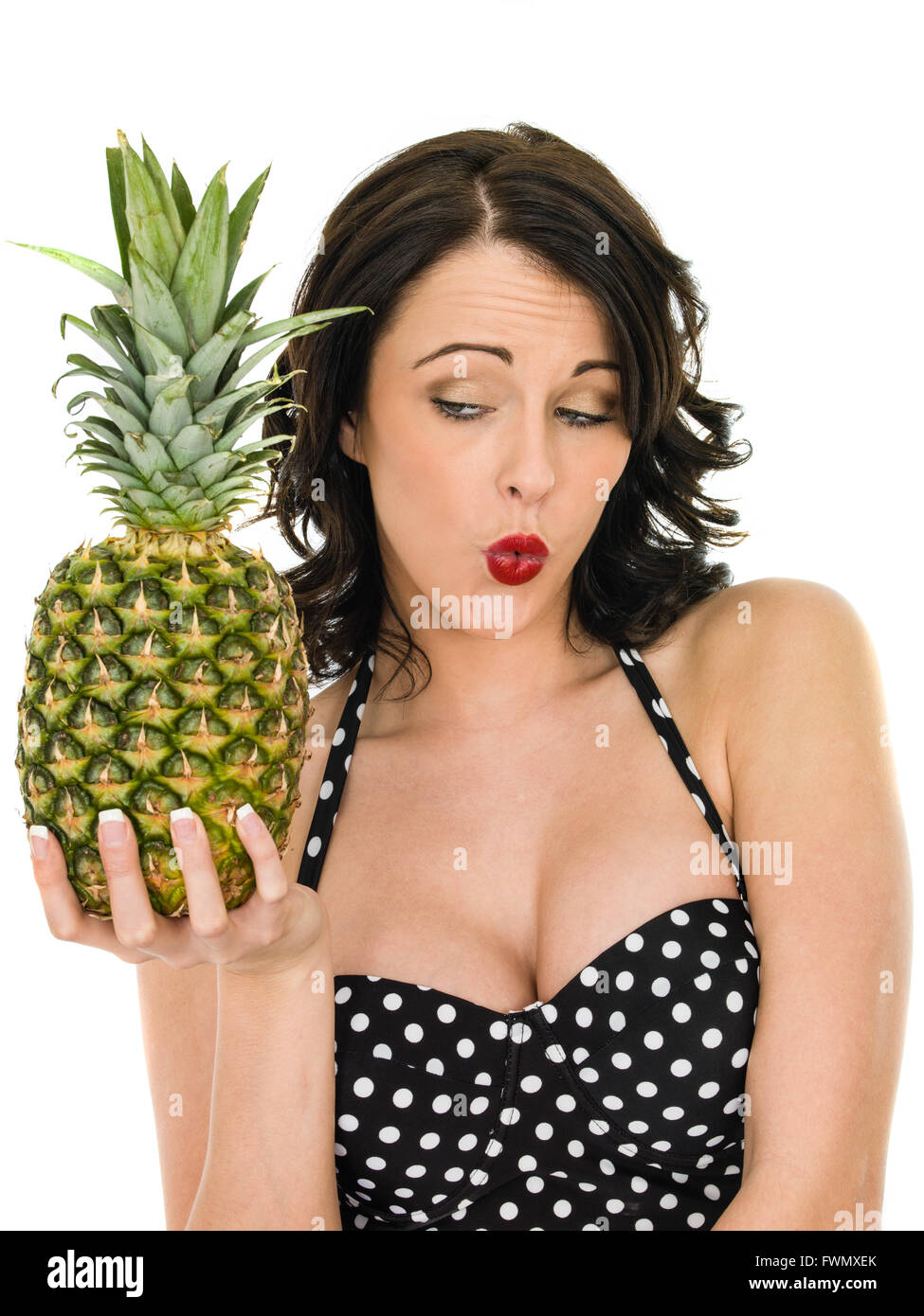 Healthy Attractive Young Woman Holding A Fresh Ripe Pineapple Isolated Against a White Background Stock Photo
