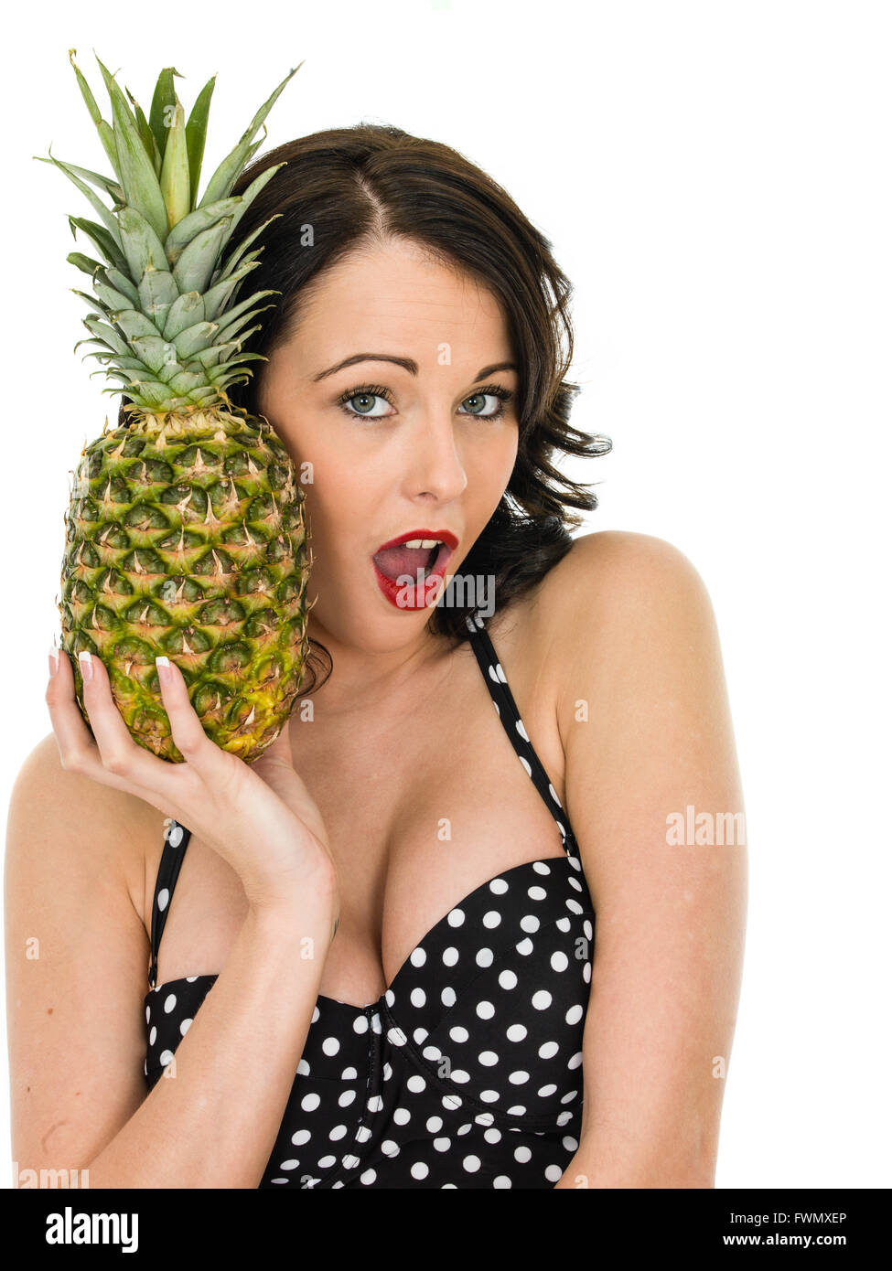 Healthy Attractive Young Woman Holding A Fresh Ripe Pineapple Isolated Against a White Background Stock Photo
