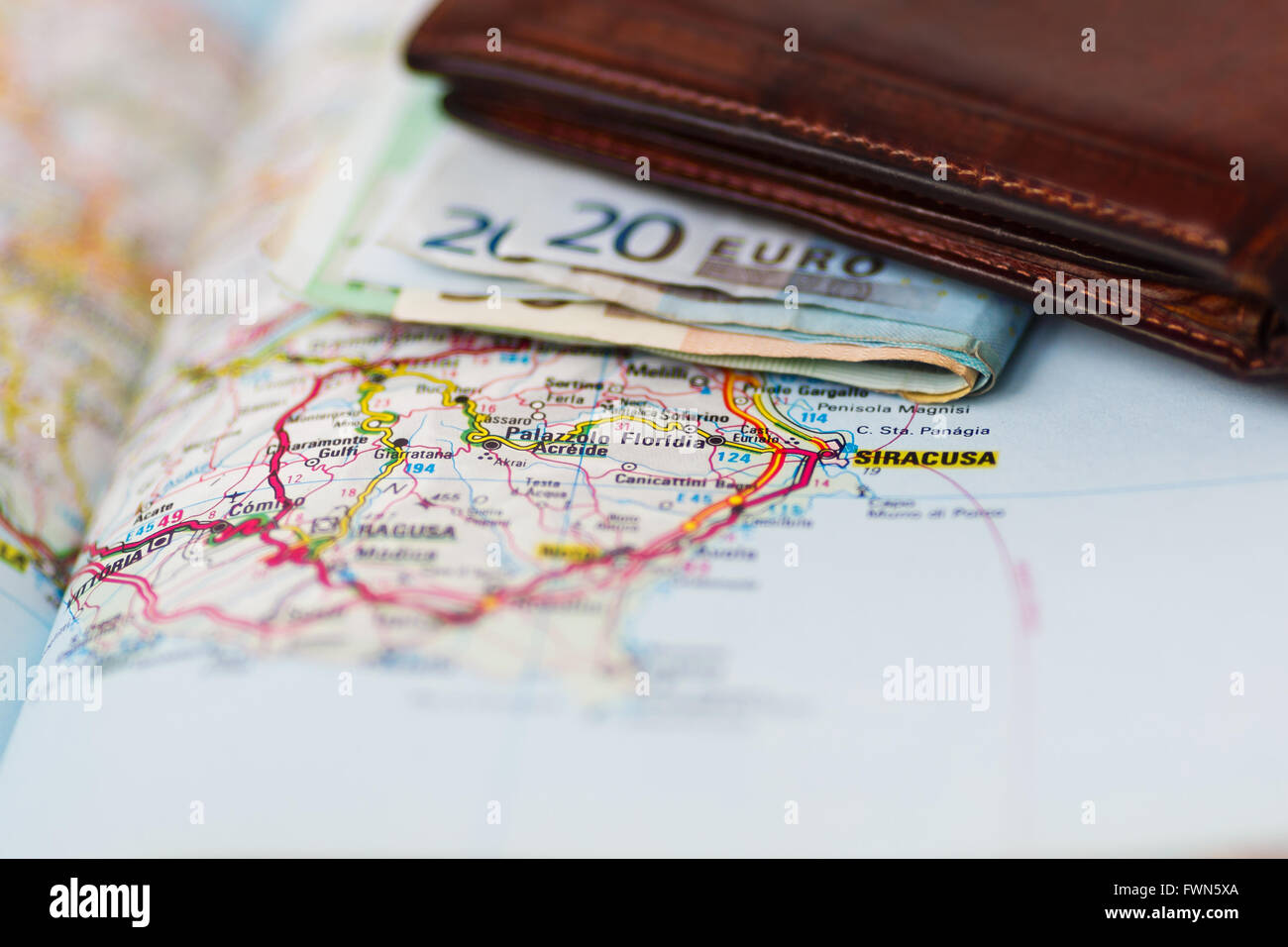 Euro banknotes inside wallet on a geographical map of Siracusa, Italy Stock Photo