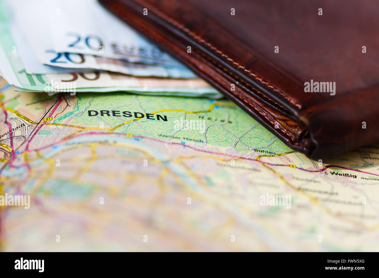 Euro banknotes inside wallet on a geographical map of Dresden, Germany Stock Photo