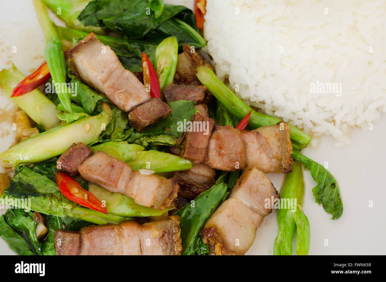 Stirfried kale with crispy pork and rice Stock Photo Alamy