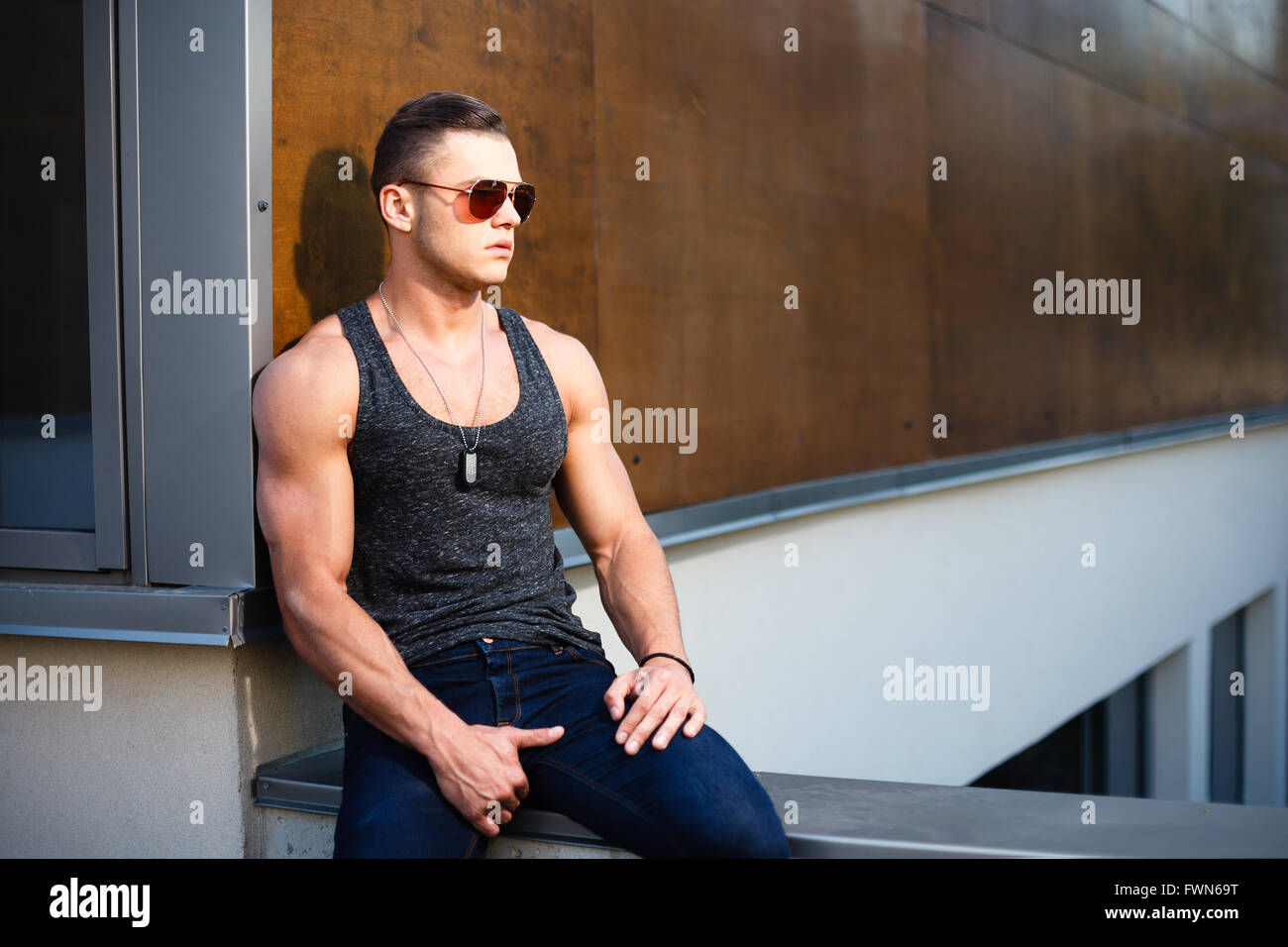 Muscular man posing near building Stock Photo