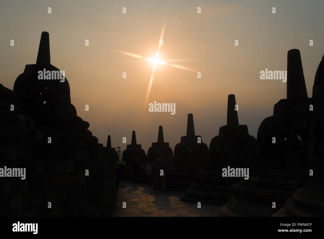 Sunset over the perforated stupas surrounding the main dome at Borobudur Temple on Aug 14, 2015 in Magelang, Indonesia. Stock Photo