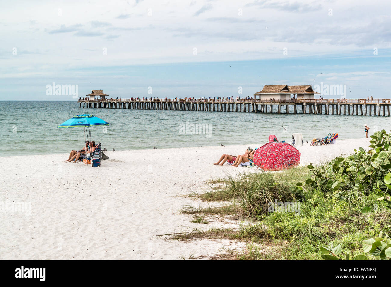 People on beach and pier in the city of Naples on the west coast of Florida, USA Stock Photo