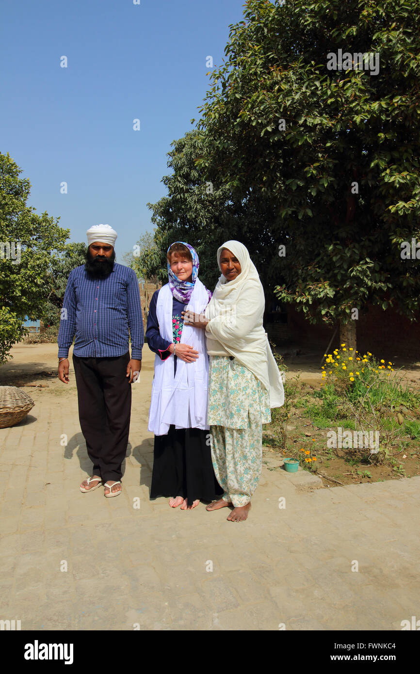 Sikhs at a Gurdwara in rural Rajasthan honour a western lady tourist by presenting her with a white sash, Stock Photo
