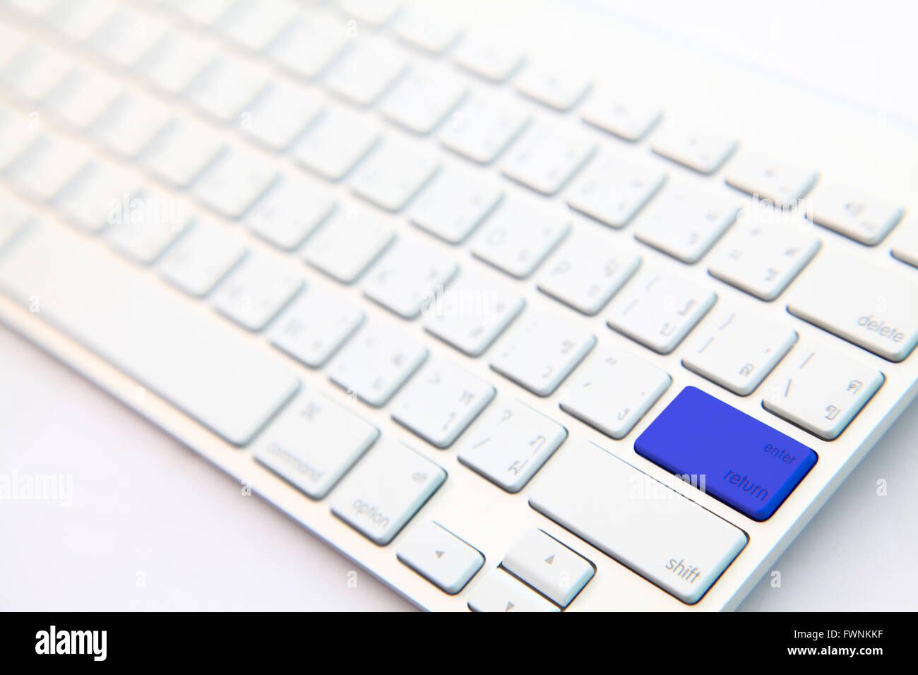 perspective of blue return button on white modern keyboard Stock Photo