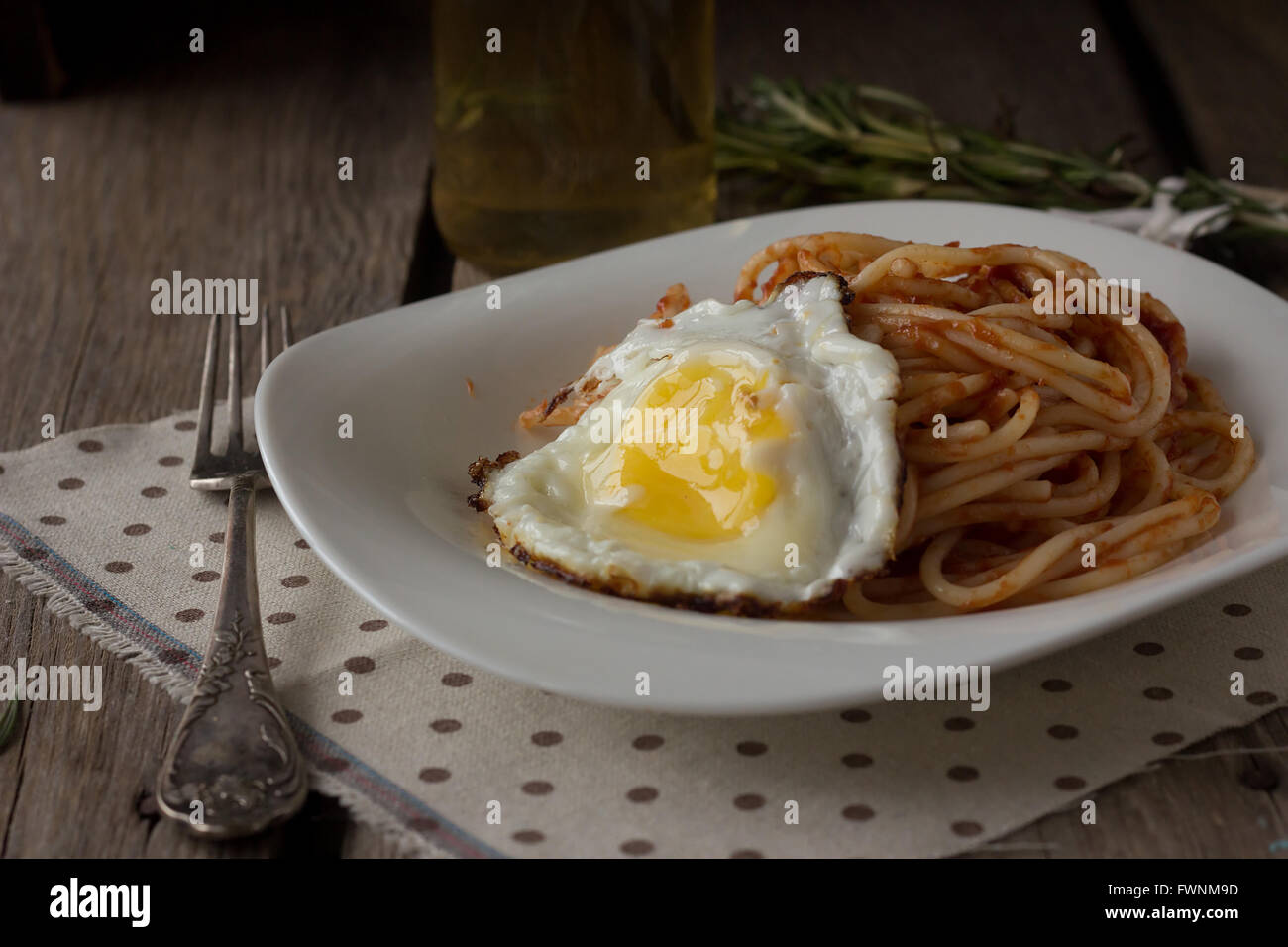 Spaghetti with tomato paste and fried egg selective focus Stock Photo