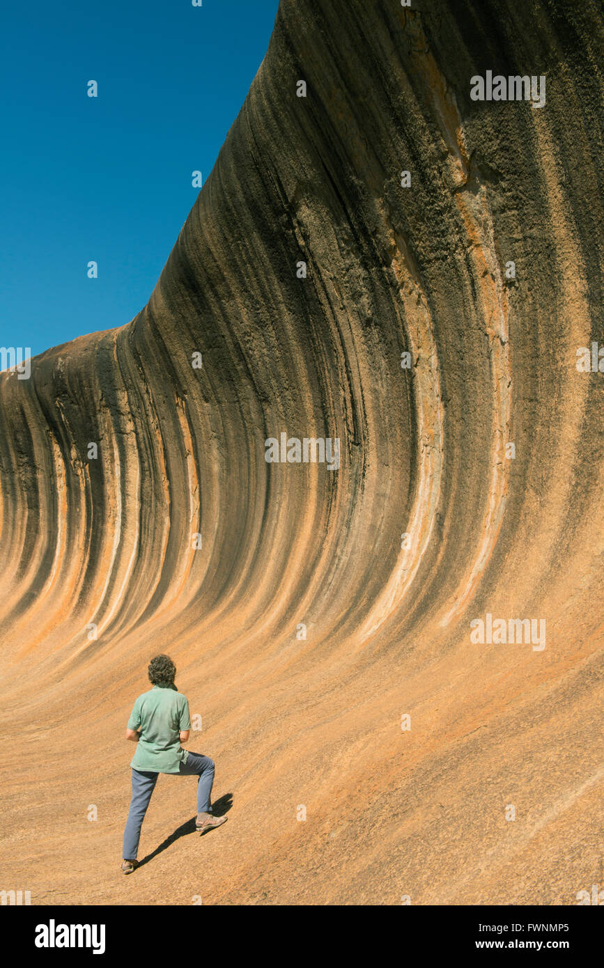 Woman and Wave Rock, striking granite formation, Western Australia Stock Photo