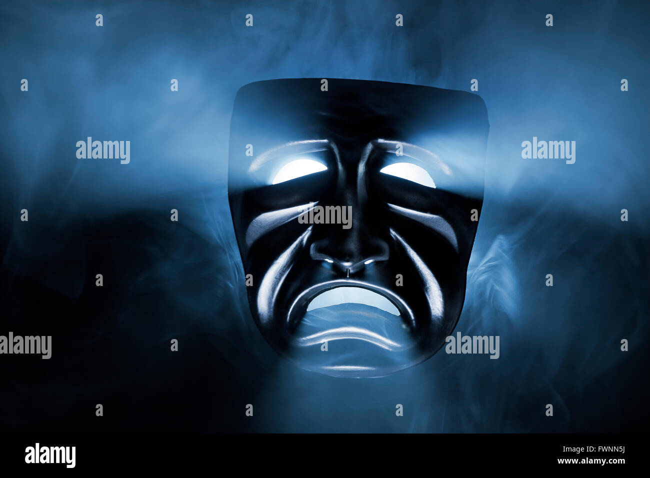 Black mask with light coming from its eyes and mouth. Stock Photo