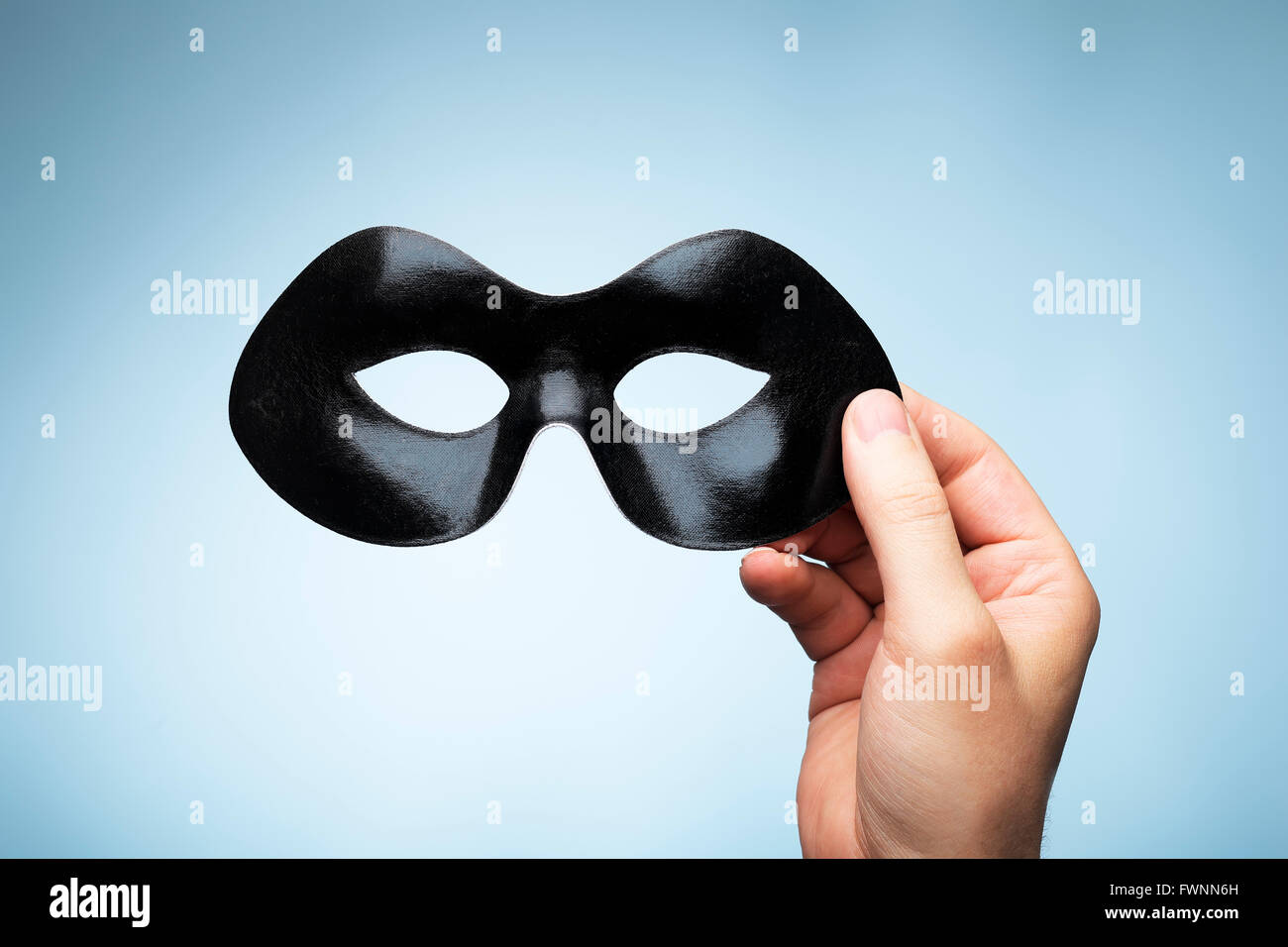 Man holding a black eyemask in his hand. Stock Photo