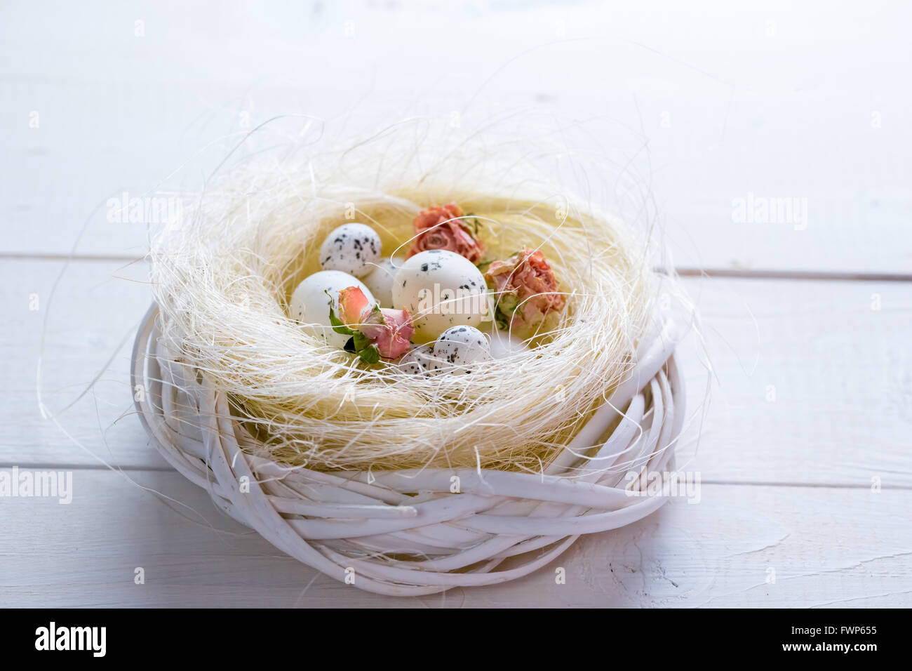 Beautiful Easter background with flowers and nest with eggs on white ...