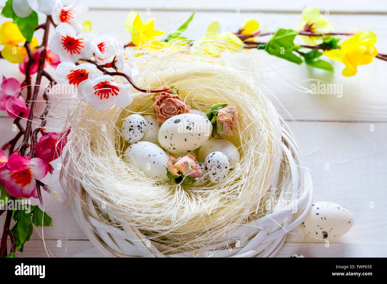 Beautiful Easter background with flowers and nest with eggs on white ...